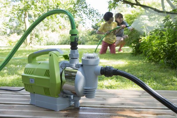 Des enfants et une pompe d'arrosage pour arroser la cours